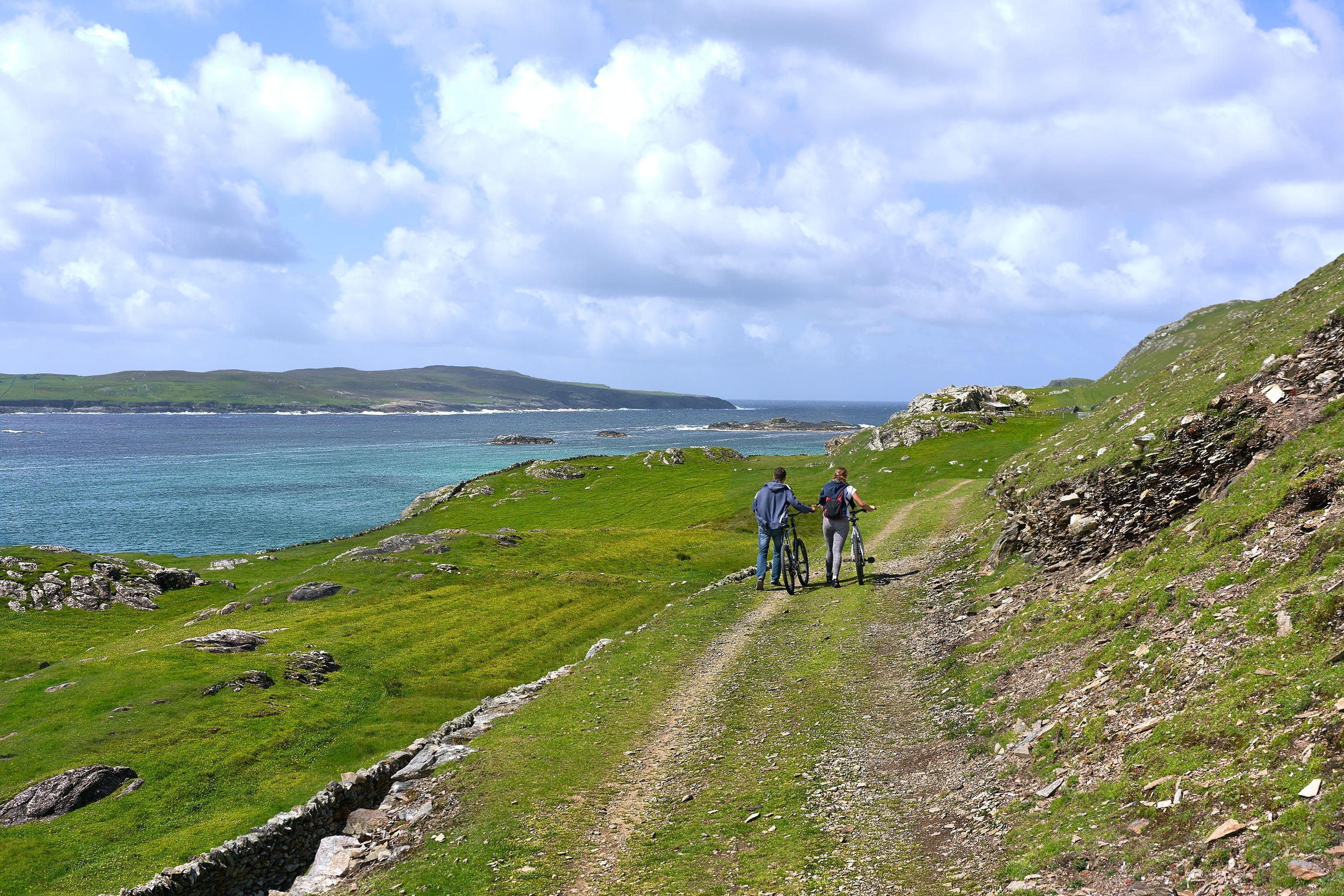 Two tourists with their bikes by the coastline in Ireland